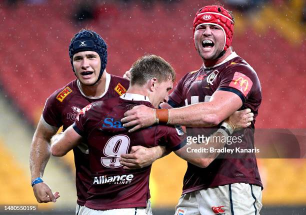 Tate McDermott of the Reds celebrates with team mates after scoring a try during the round seven Super Rugby Pacific match between Queensland Reds...