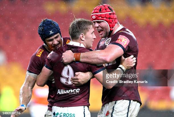 Tate McDermott of the Reds celebrates with team mates after scoring a try during the round seven Super Rugby Pacific match between Queensland Reds...