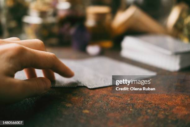 hand touching tarot cards on rusty surface. - tarot photos et images de collection