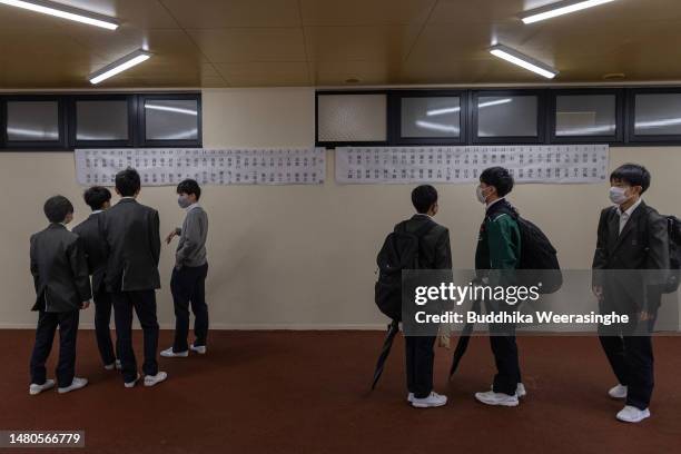 Junior High school students check their names prior to entering the first day of the new academic year at New Sannan Junior High School on April 07,...