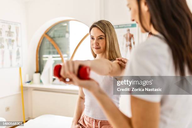 young woman with physical therapist - naturopath stock pictures, royalty-free photos & images