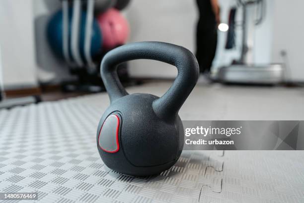 kettlebell on the gym floor - kettle bell stock pictures, royalty-free photos & images