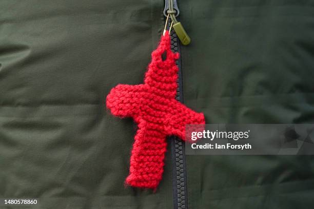 Pilgrim wears a knitted cross as they walk across the tidal causeway to Lindisfarne during the final leg of their annual Good Friday pilgrimage on...