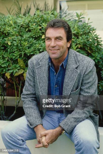 American actor Tom Selleck wearing a grey tweed jacket over a blue denim shirt and jeans, United States, circa 1983.