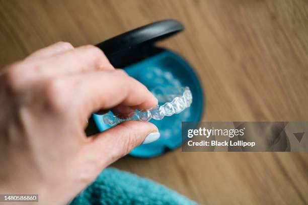 woman's hand holding  invisible aligners. - invisalign stock pictures, royalty-free photos & images