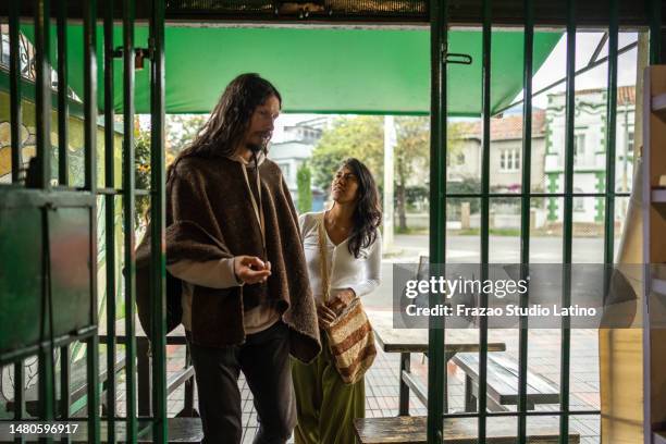 couple entering on a coffee shop or local market - hipster coffee shop candid stock pictures, royalty-free photos & images