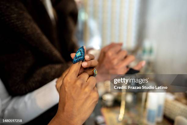 mid adult woman trying on a ring at bazaar - artisanal food and drink stock pictures, royalty-free photos & images