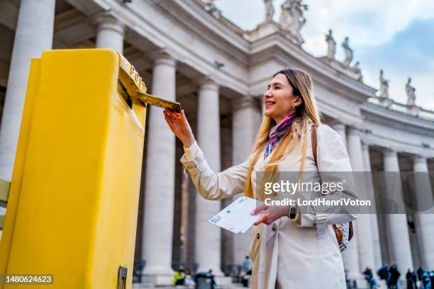 frau wirft eine postkarte in den briefkasten des vatikans - religious service stock-fotos und bilder
