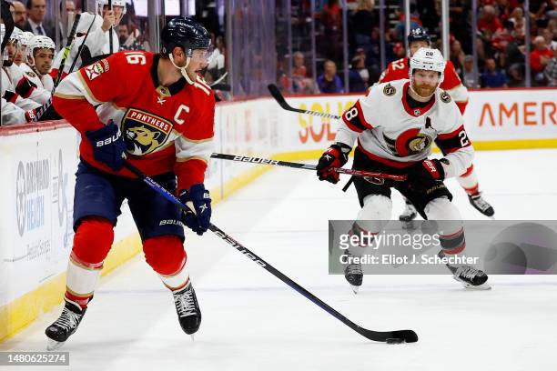 Aleksander Barkov of the Florida Panthers skates with the puck against Claude Giroux of the Ottawa Senators at the FLA Live Arena on April 6, 2023 in...