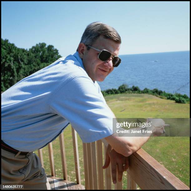 Portrait of American author Tom Clancy as he leans on the deck of his home , Prince Frederick, Maryland, August 1990.