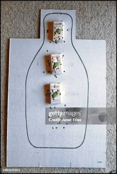 Close-up of a homemade shooting target, decorated with three packs of Merit cigarettes, Prince Frederick, Maryland , August 1990. The target was shot...