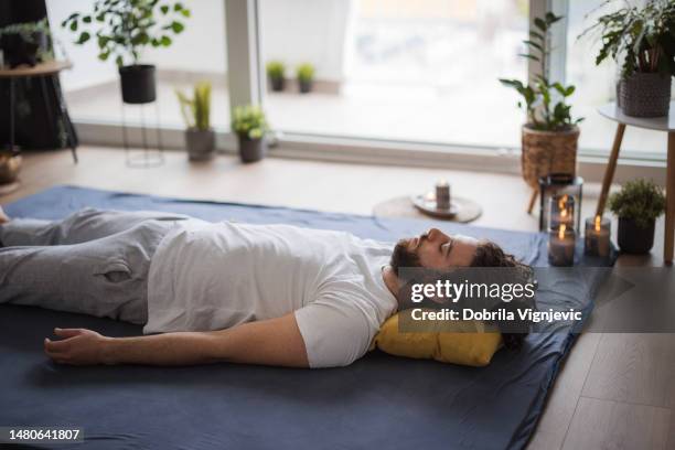 homme reposant sur un tapis sur le sol après un massage shiatsu - male male massage photos et images de collection
