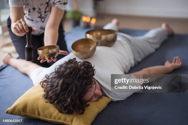 man having tibetan singing bowl massage - tibetan culture stock pictures, royalty-free photos & images