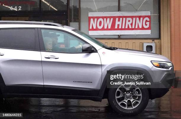 Car drives by a now hiring sign posted in front of a CVS store on April 07, 2023 in San Rafael, California. The U.S. Labor market added 236,000 jobs...