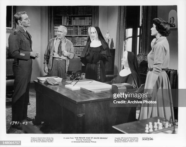 Charlton Heston talking to the school nuns as Julie Adams watches in a scene from the film 'The Private War Of Major Benson', 1955.