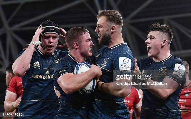 Scott Penny of Leinster Rugby celebrates with teammates after scoring the team's fourth try during the Heineken Champions Cup Quarter Finals match at...