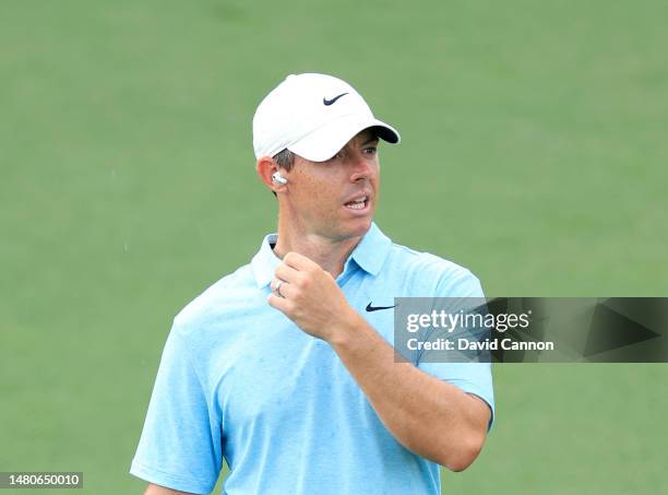 Rory McIlroy of Northern Ireland prepares to play his second shot on the ninth hole as he talks to CBS television through earpods during the first...