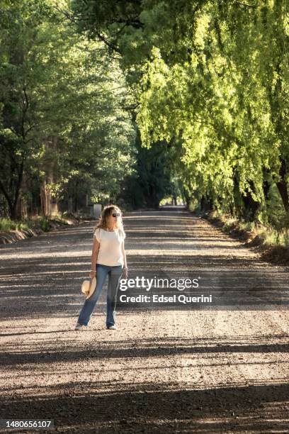 mujer caminando bajo frondosos árboles. uspallata, las heras, mendoza, argentina. - mendoza argentina fotografías e imágenes de stock