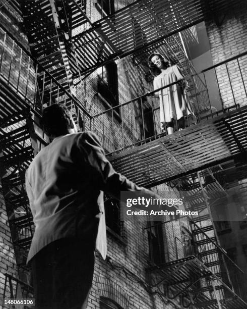 Natalie Wood standing high upon a stairwell looking down at the man standing on the ground floor in a scene from the film 'West Side Story', 1961.