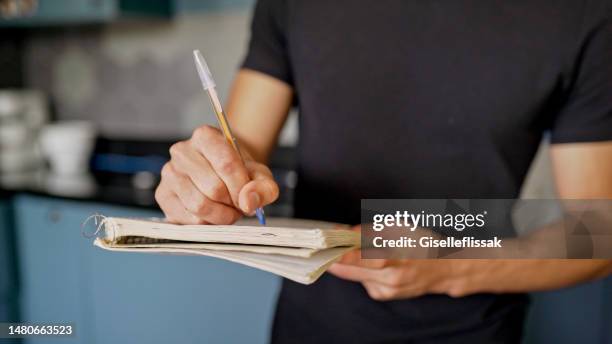 joven tomando notas durante una clase de cocina - caderno de receitas fotografías e imágenes de stock