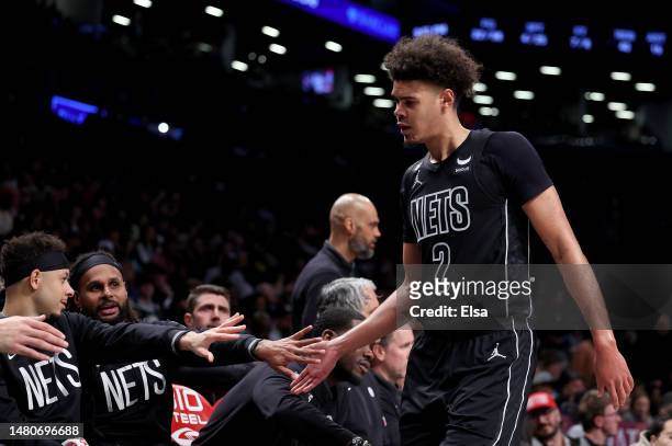 Cameron Johnson of the Brooklyn Nets is greeted by teammates on the bench in the second half against the Orlando Magic at Barclays Center on April...