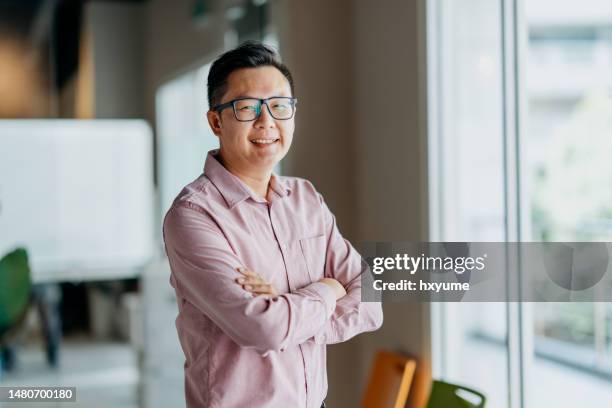 smiling and confidence businessman in office - mature men office stock pictures, royalty-free photos & images