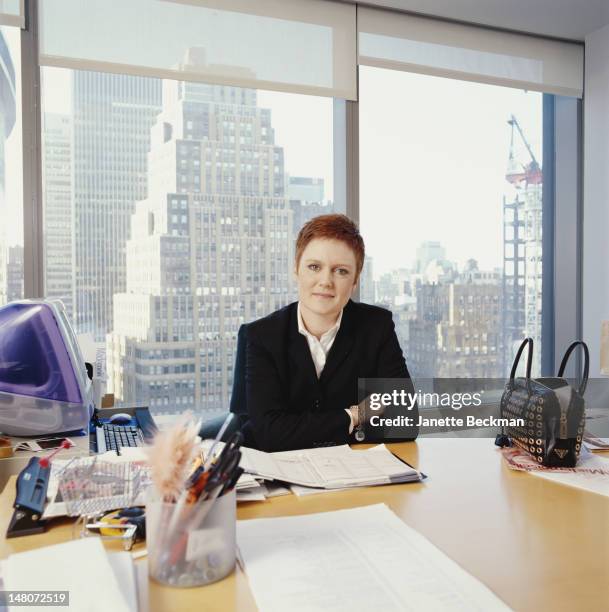 Portrait of British-born magazine editor Mandi Norwood of Mademoiselle as she sits at her desk in her office, New York, New York, 2000.