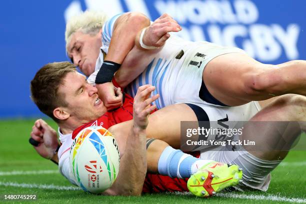 Tom Williams of Great Britain collides with Luciano Gonzalez of Argentina after scoring a try in their pool match during the HSBC Singapore Rugby...