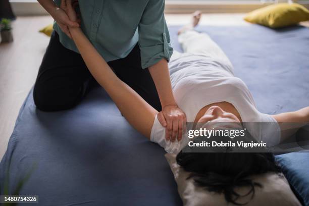 woman having shoulders and arms stretched during massage - pressure ulcer stockfoto's en -beelden