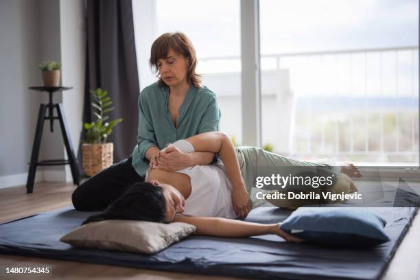 femme allongée sur le côté et ayant un côté du haut du corps étiré - réflexologie photos et images de collection