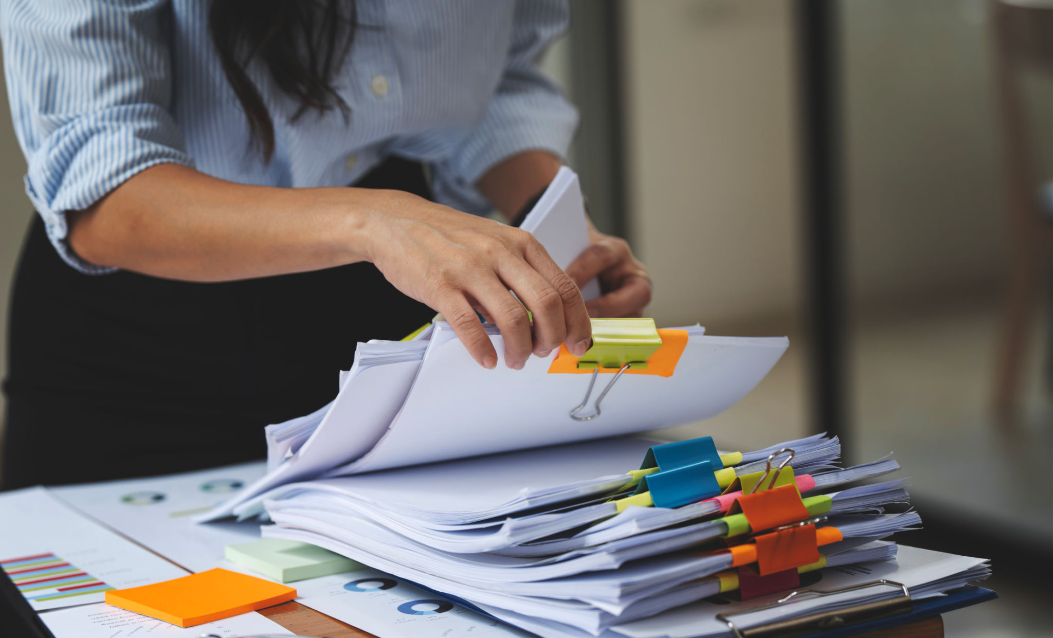 Businesswoman hands working in Stacks of paper files for searching and checking unfinished document achieves on folders papers Businesswoman hands working in Stacks of paper files for searching and checking unfinished document achieves on folders papers