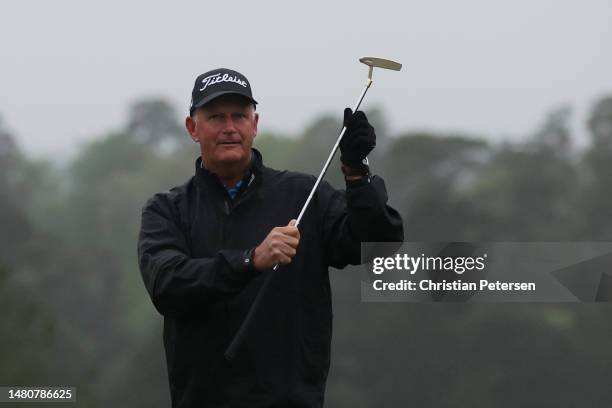 Sandy Lyle of Scotland shows patrons his replica gold putter from his 1988 Masters win before putting on the 18th green during the continuation of...