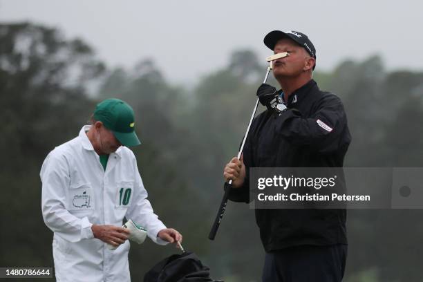 Sandy Lyle of Scotland kisses his replica gold putter from his 1988 Masters win before putting on the 18th green during the continuation of the...