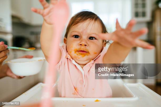 mutter füttert ihr baby girl - baby spielt mit essen stock-fotos und bilder