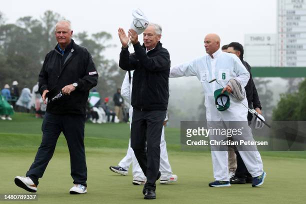 Sandy Lyle of Scotland and Larry Mize of the United States acknowledge patrons on the 18th green during the continuation of the weather delayed...