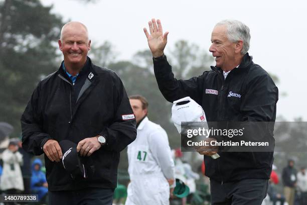 Sandy Lyle of Scotland and Larry Mize of the United States acknowledge patrons on the 18th green during the continuation of the weather delayed...