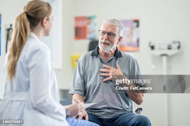 senior a un appuntamento medico - dolore al petto foto e immagini stock