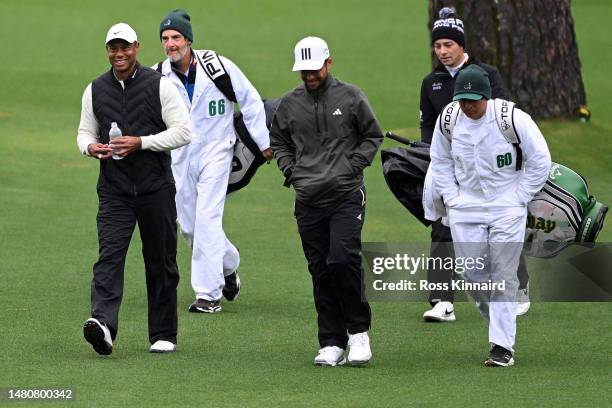 Tiger Woods of the United States, Xander Schauffele of the United States and Viktor Hovland of Norway walk to the 16th green during the continuation...