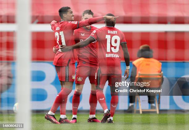 Amine Adli of Bayer 04 Leverkusen celebrates with teammates Florian Wirtz and Moussa Diaby after scoring the team's first goal during the Bundesliga...