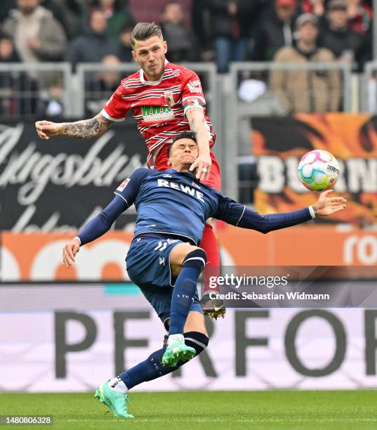 Davie Selke of 1.FC Koln is challenged by Jeffrey Gouweleeuw of FC Augsburg during the Bundesliga match between FC Augsburg and 1. FC Köln at...