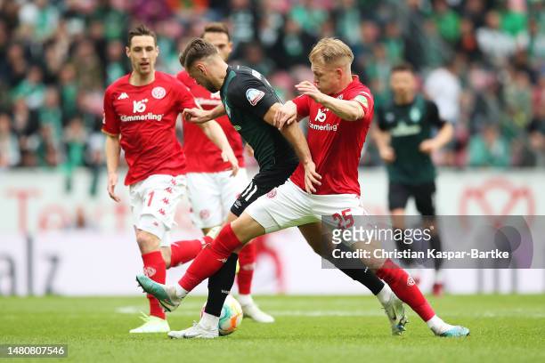 Niclas Fuellkrug of SV Werder Bremen is challenged by Andreas Hanche-Olsen of 1.FSV Mainz 05 during the Bundesliga match between 1. FSV Mainz 05 and...