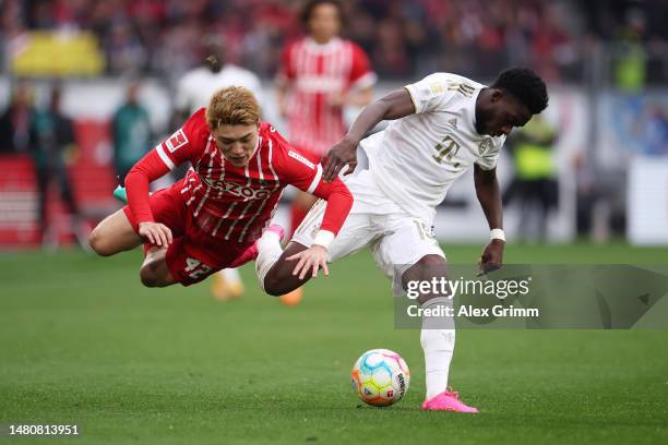 Ritsu Doan of SC Freiburg clashes with Alphonso Davies of Bayern Munich during the Bundesliga match between Sport-Club Freiburg and FC Bayern München...