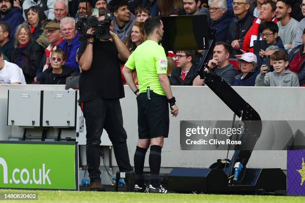 Referee, Chris Kavanagh checks the VAR screen regarding Brentford's second goal during the Premier League match between Brentford FC and Newcastle...