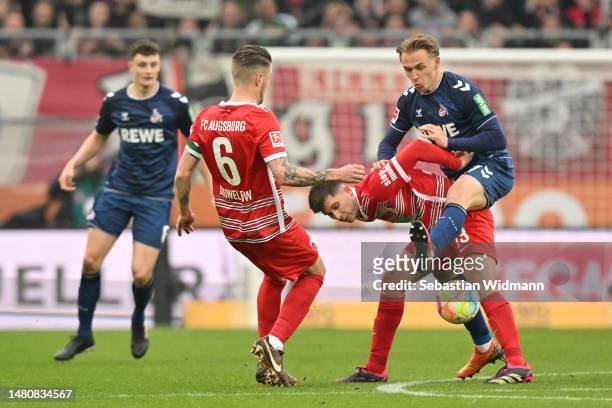 Elvis Rexhbecaj of FC Augsburg and Mathias Flaga Olesen of 1.FC Köln compete for the ball during the Bundesliga match between FC Augsburg and 1. FC...