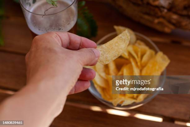 eating potato chips and drinking beer - crisps foto e immagini stock