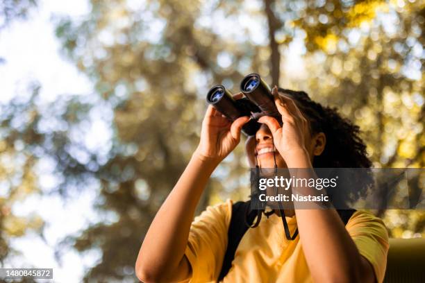 female hiker watching through binoculars - fågelskådning bildbanksfoton och bilder