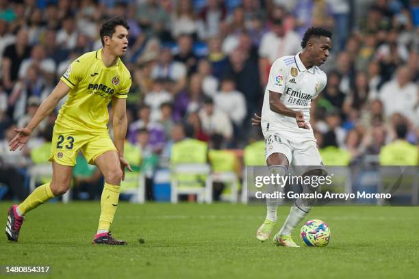Vinicius Junior of Real Madrid CF scores their second goal ahead Aissa Mandi during the LaLiga Santander match between Real Madrid CF and Villarreal...