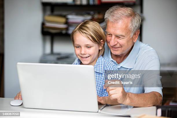 young boy helping grandfather with computer - old pc stock pictures, royalty-free photos & images