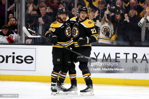 Hampus Lindholm of the Boston Bruins celebrates with David Pastrnak after Pavel Zacha scored a goal against the New Jersey Devils during the first...