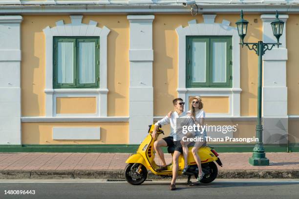 a couple goes on holiday with their scooter - montar un vehículo fotografías e imágenes de stock